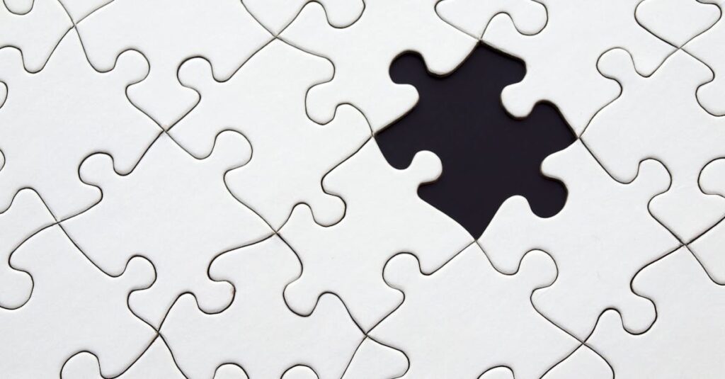 Close-up of an incomplete white puzzle with one missing piece, symbolizing challenge and strategy.